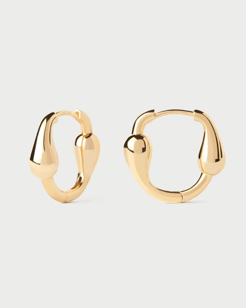 Sculptural oval huggie hoops with asymmetric design featuring elongated drop-shaped motifs