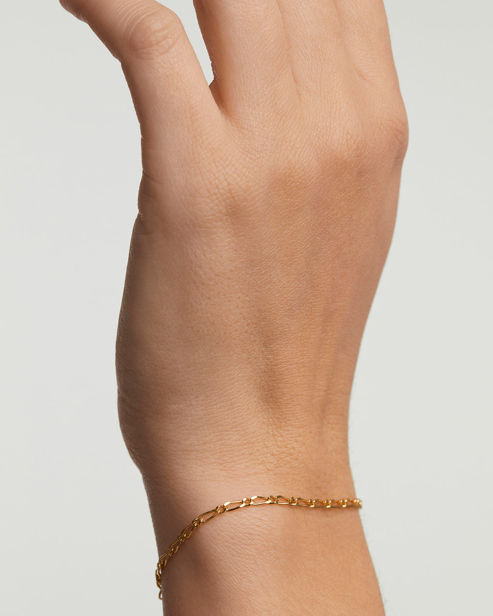 Gold-plated sleek chain bracelet with intertwined asymmetric links 