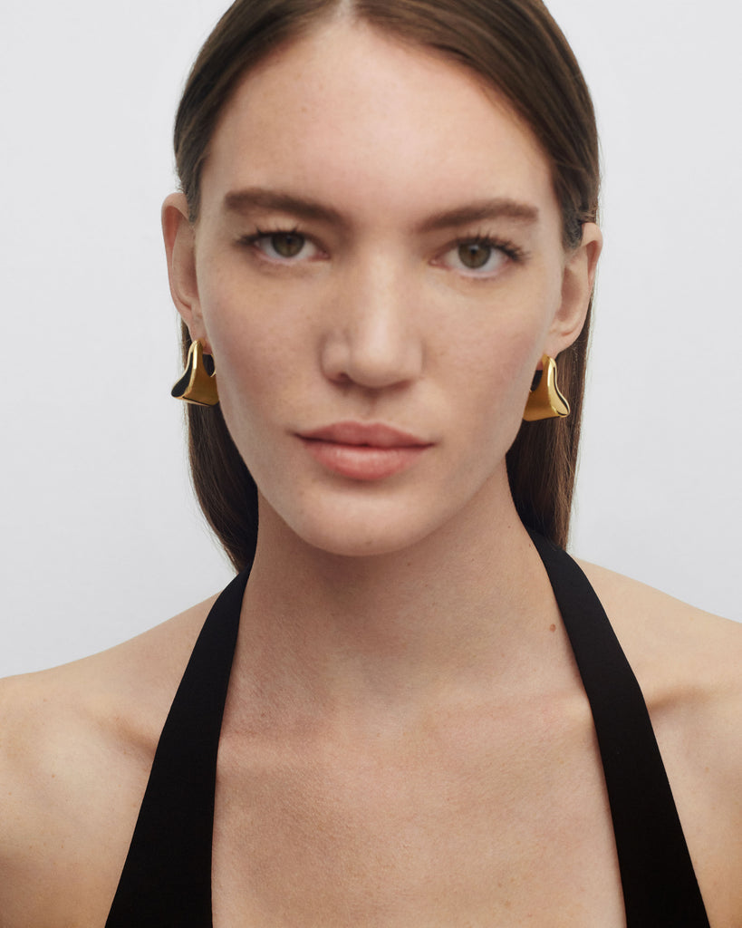 Gold-plated oversized geometric hoop earrings with a wavy bean shape ...