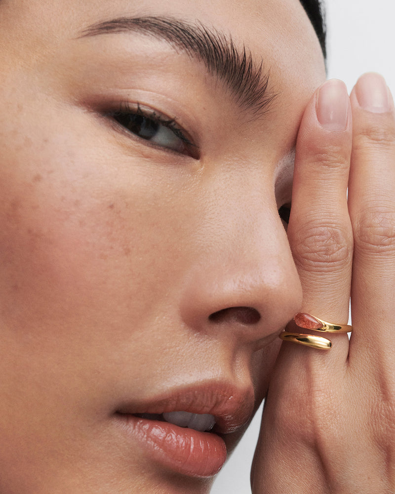 Gold-plated fluid open ring embellished with an orange oval gemstone