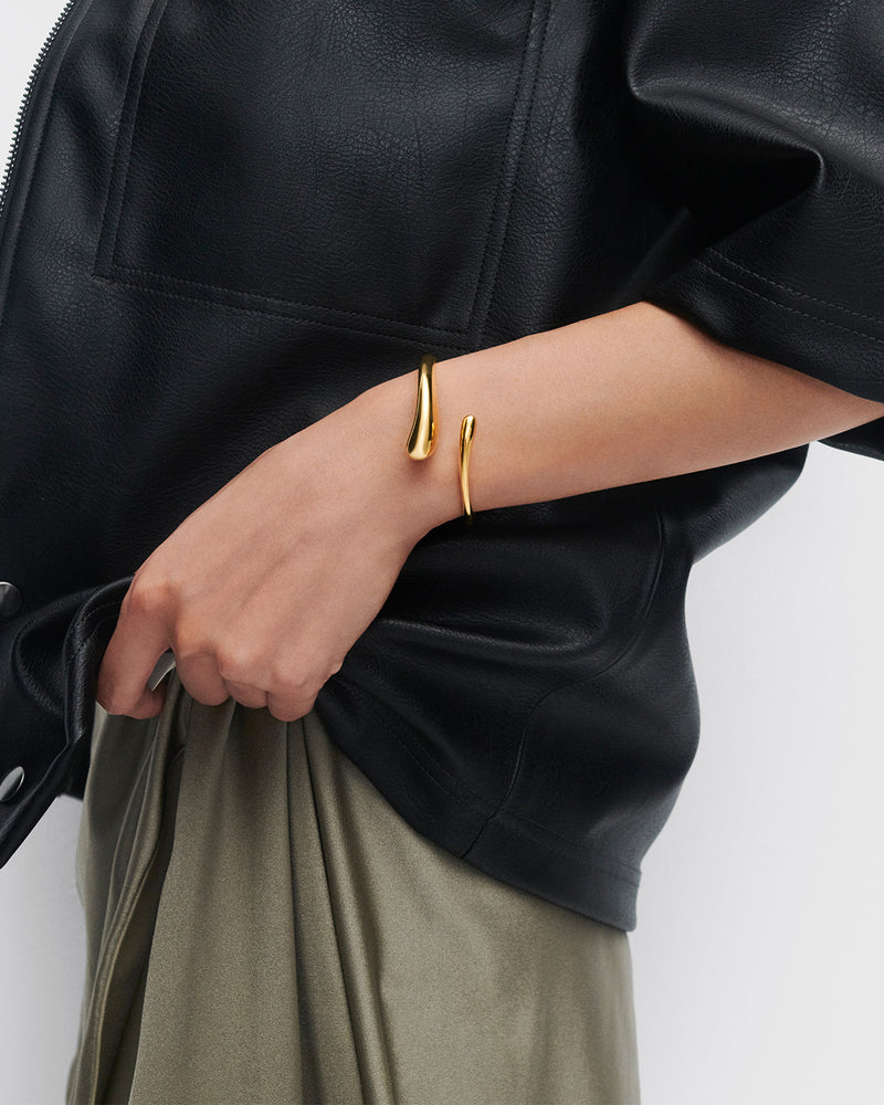 Gold-plated open bangle bracelet with a sculptural drop design